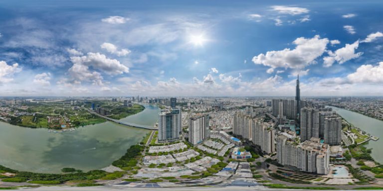 Ảnh flycam 360 toàn cảnh khu đô thị ven sông với các tòa cao tầng, cầu và mảng xanh xung quanh