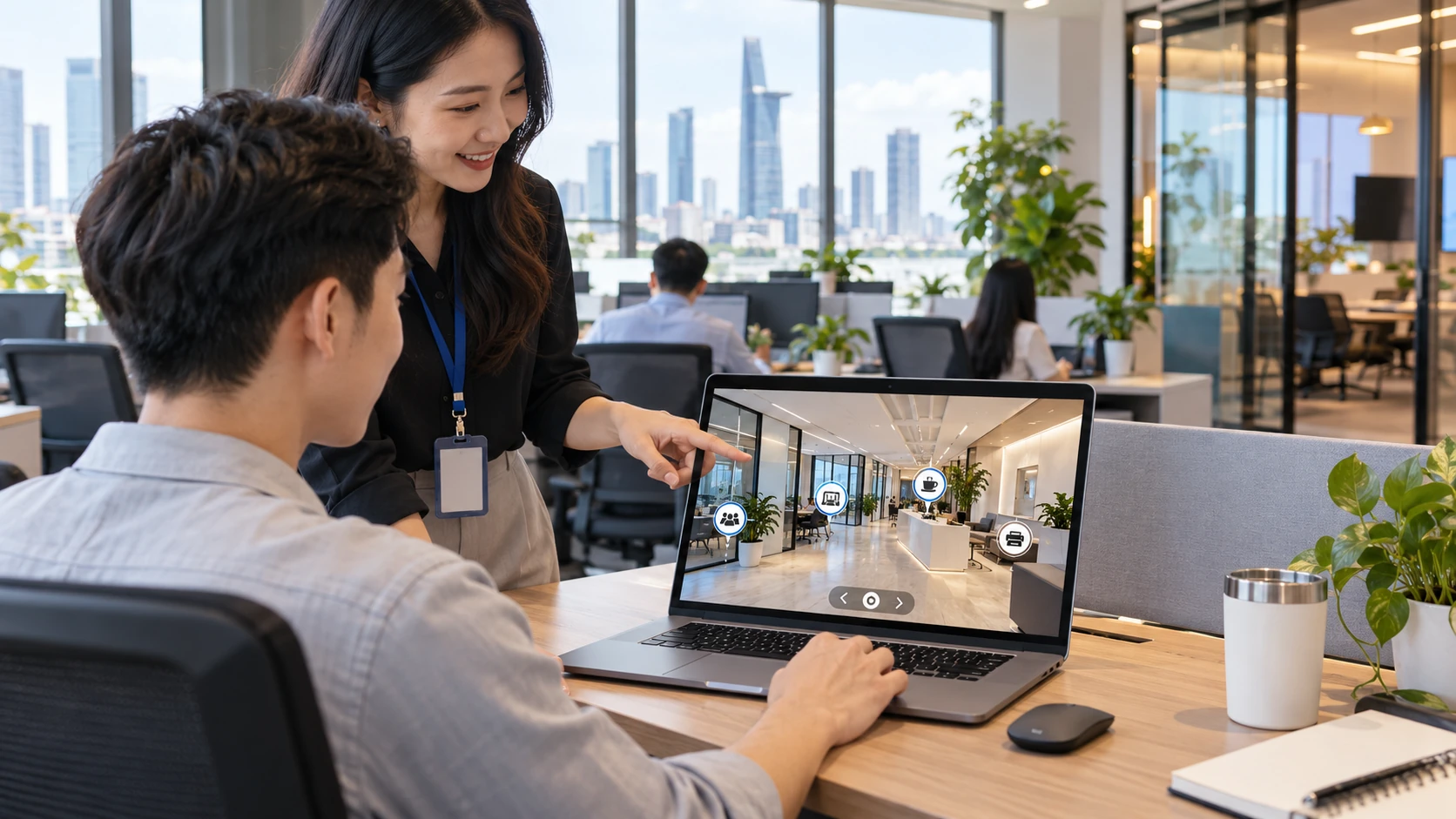 Chuyên viên nhân sự hướng dẫn nhân viên mới xem VR tour văn phòng có hotspot trên laptop, ảnh minh hoạ
