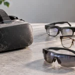 Kính thực tế ảo VR cũ phủ bụi đặt cạnh ba mẫu kính thông minh mới trên mặt bàn đá